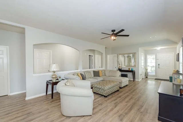 a living room with furniture and a ceiling fan