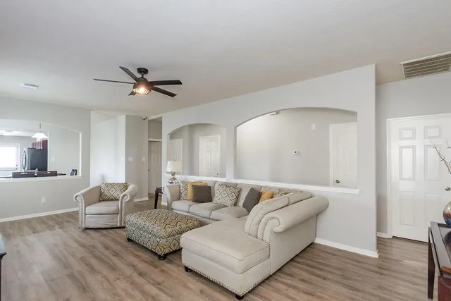a living room with furniture and a large mirror with wooden floor