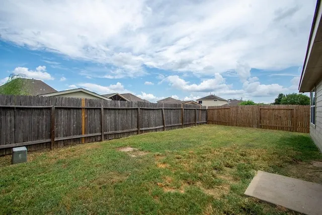 a view of a backyard with wooden fence