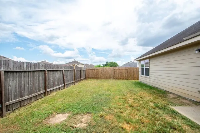 a view of a backyard with wooden fence