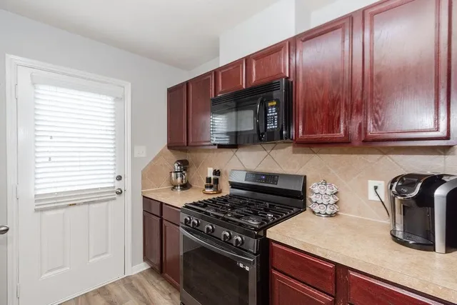 a kitchen with granite countertop wooden cabinets and a stove top oven