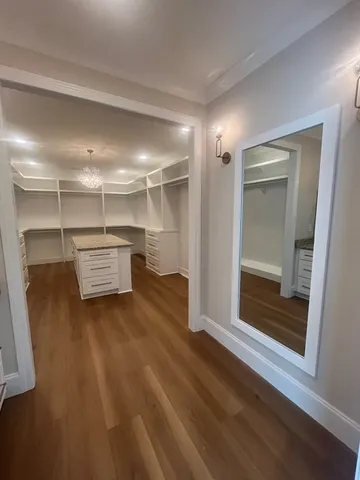 a view of a room with wooden floor cabinet and a bathroom