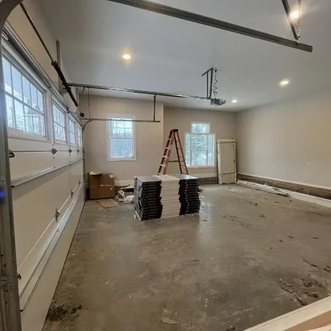 an empty room with wooden floor fireplace and windows