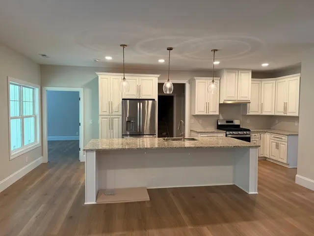 a kitchen with granite countertop white cabinets and stainless steel appliances
