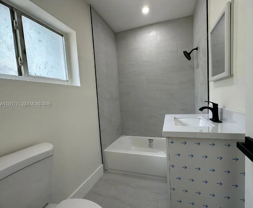 1514 Southwest 6th Street, Unit 4 Miami, FL 33135 - Photo 3 of 6 a bathroom with a sink a toilet and mirror