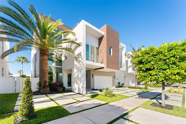 a view of a white building with a yard