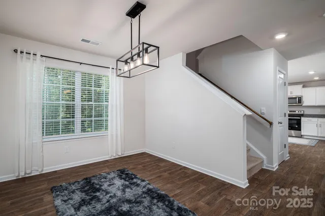 a view of a livingroom with wooden floor and stairs