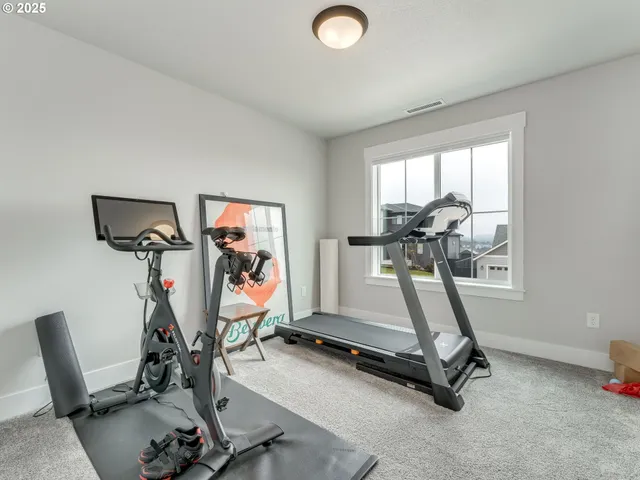 a spacious bedroom with a bed a table and windows