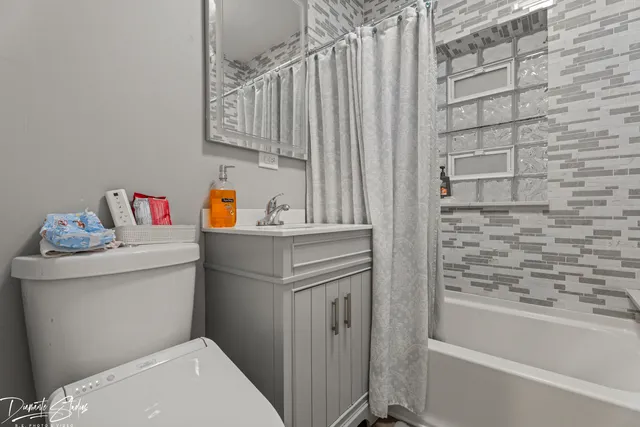 a bathroom with a sink toilet vanity and tub