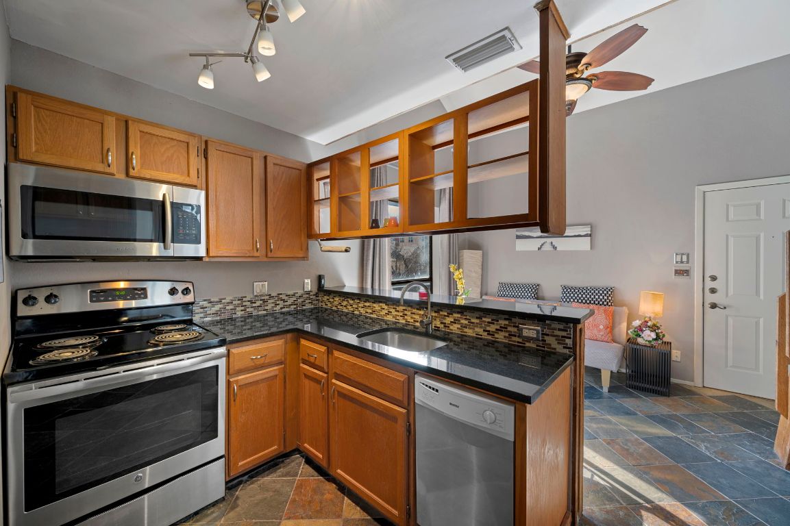 2210 Pearl Street, Unit 301 Austin, TX 78705 - Photo 7 of 35 a kitchen with stainless steel appliances granite countertop a stove and a microwave