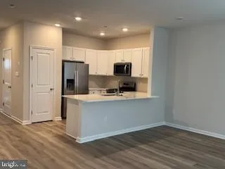 a kitchen with stainless steel appliances a refrigerator microwave and sink