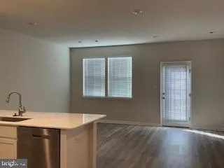 a kitchen with a sink cabinets and wooden floor
