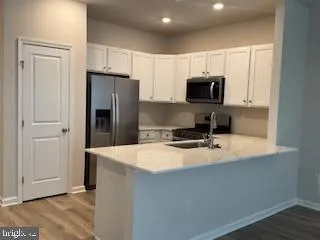 a kitchen with stainless steel appliances granite countertop a refrigerator microwave and sink