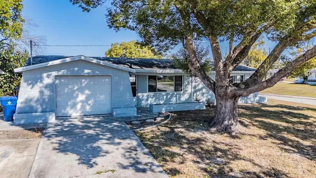 a front view of a house with a yard and a garden