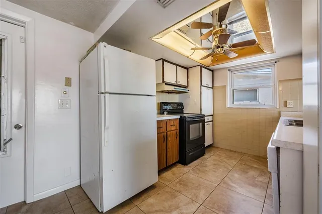 a kitchen with stainless steel appliances granite countertop a refrigerator a stove and a sink
