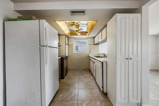 a kitchen with stainless steel appliances granite countertop a refrigerator a stove and a sink