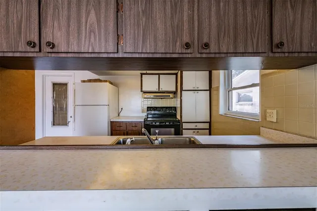 a kitchen with stainless steel appliances granite countertop a stove a sink and a refrigerator