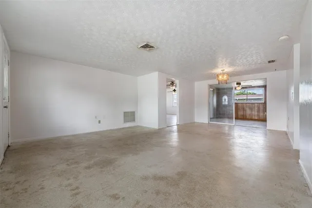 a view of an empty room with a kitchen