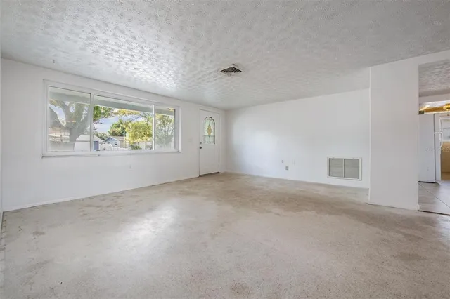 en empty room with windows and chandelier