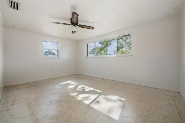 a view of an empty room and a ceiling fan