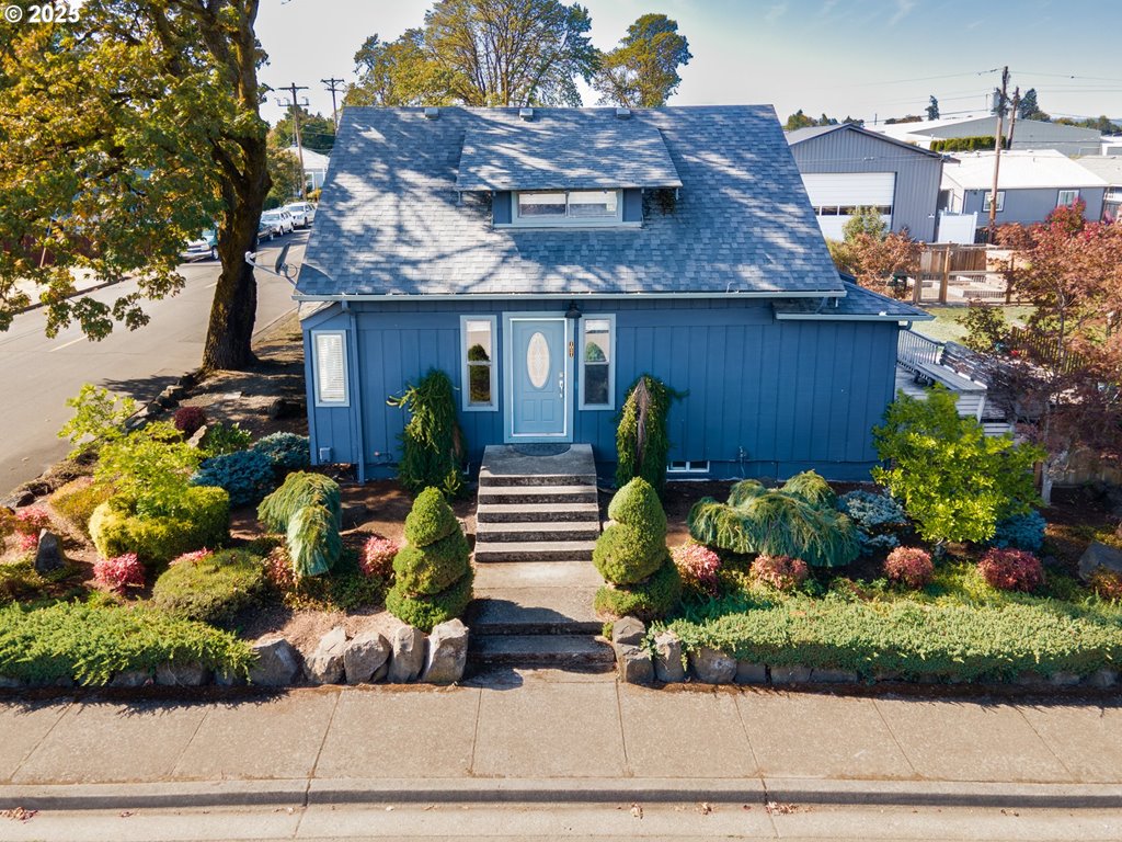 a front view of a house with a yard and a garden