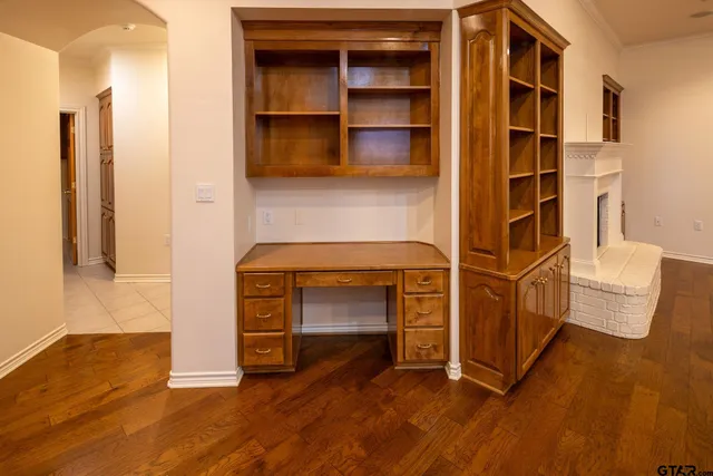 a view of an empty room with cabinet and a fireplace
