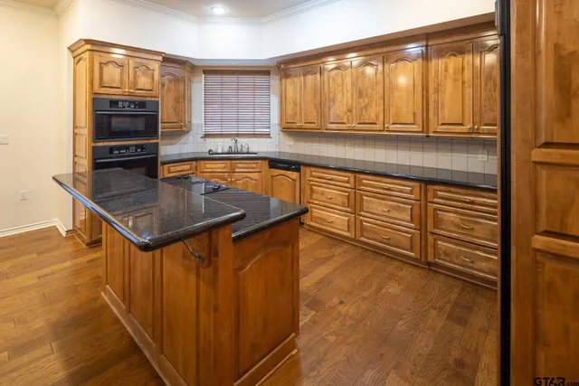 a kitchen with stainless steel appliances granite countertop a sink and a stove