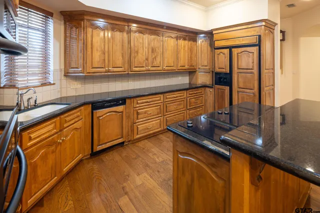 a kitchen with stainless steel appliances granite countertop a sink stove and cabinets