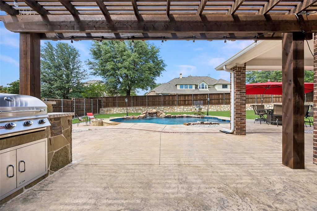 1011 Three Rivers Drive Prosper, TX 75078 - Photo 20 of 27 a view of a patio with a table and chairs under an umbrella