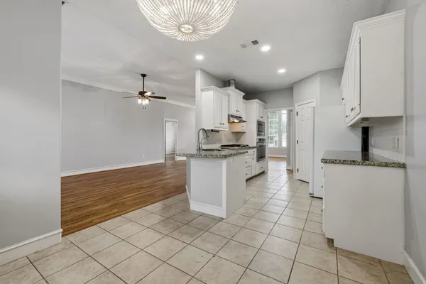a kitchen with kitchen island granite countertop a sink stove and cabinets