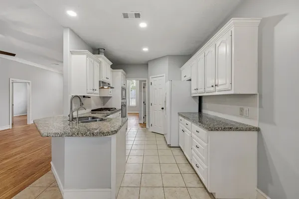 a kitchen with granite countertop white cabinets and white appliances