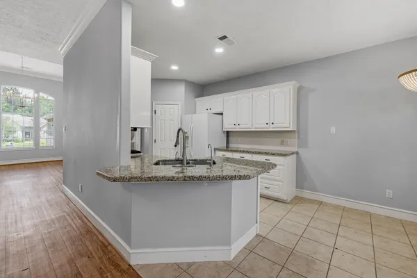 a kitchen with granite countertop white cabinets and a stove