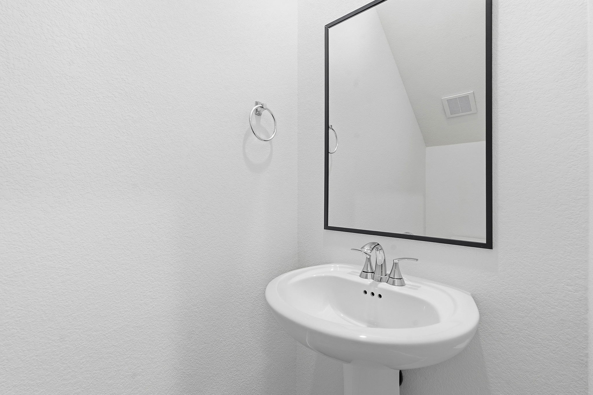 164 Cinnabar Lane, Unit 3 Kyle, TX 78640 - Photo 9 of 20 Pedestal sink with chrome faucet, framed mirror, and white textured walls