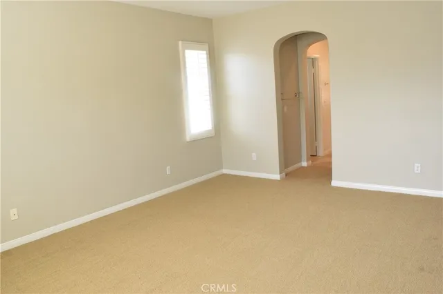 an empty room with wooden floor and fan