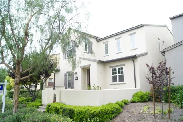 a view of a white house with a large windows and plants