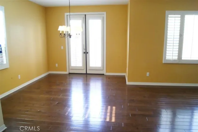 a view of a room with wooden floor and a window