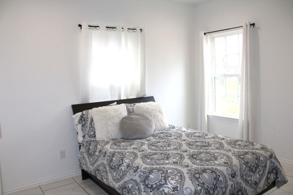 7320 County Road 3512 Quinlan, TX 75474 - Photo 25 of 35 a large bed sitting in a bedroom next to a window