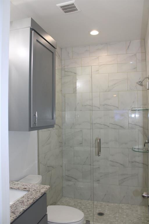 7320 County Road 3512 Quinlan, TX 75474 - Photo 26 of 35 a bathroom with a granite countertop sink a toilet and shower