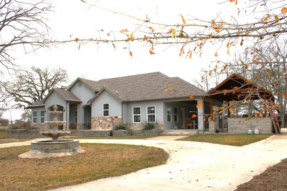 7320 County Road 3512 Quinlan, TX 75474 - Photo 4 of 35 a front view of a house with a yard and fountain