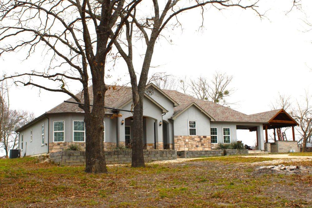 7320 County Road 3512 Quinlan, TX 75474 - Photo 5 of 35 a front view of a house with a yard outdoor seating and garage