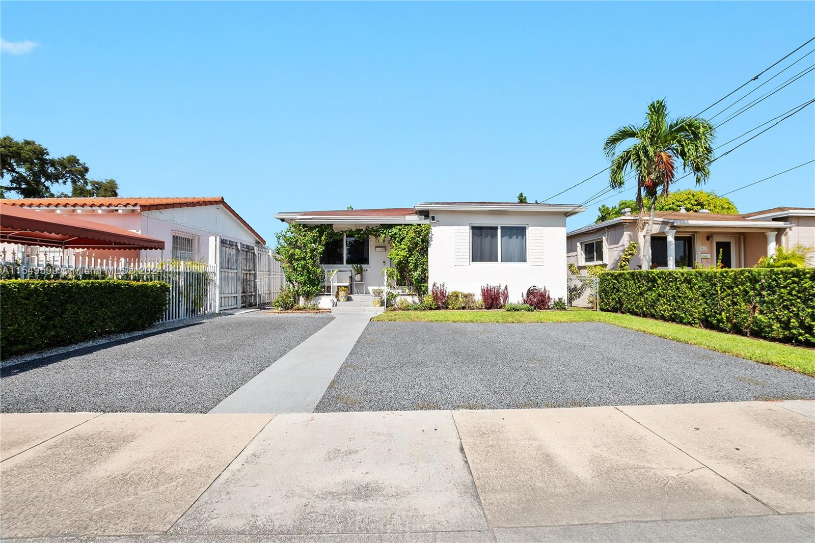 a front view of a house with a yard and potted plants