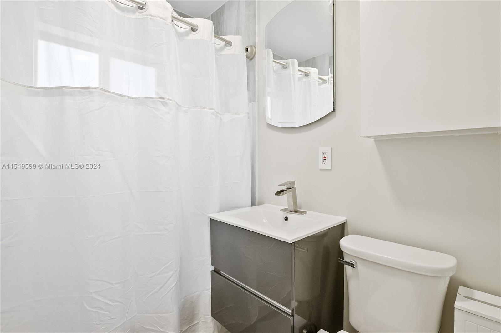 5819 Southwest 4th Street Miami, FL 33144 - Photo 11 of 27 a bathroom with a sink a toilet and a mirror