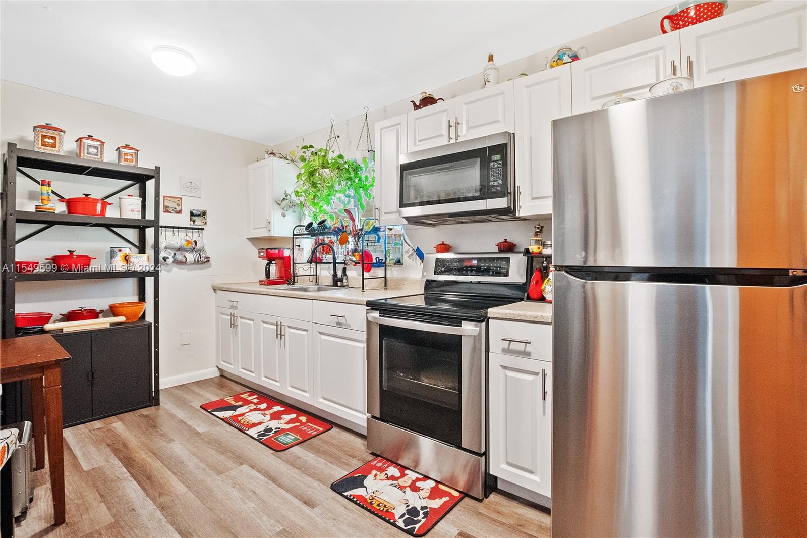 5819 Southwest 4th Street Miami, FL 33144 - Photo 18 of 27 a kitchen with stainless steel appliances a chimney a sink and a refrigerator
