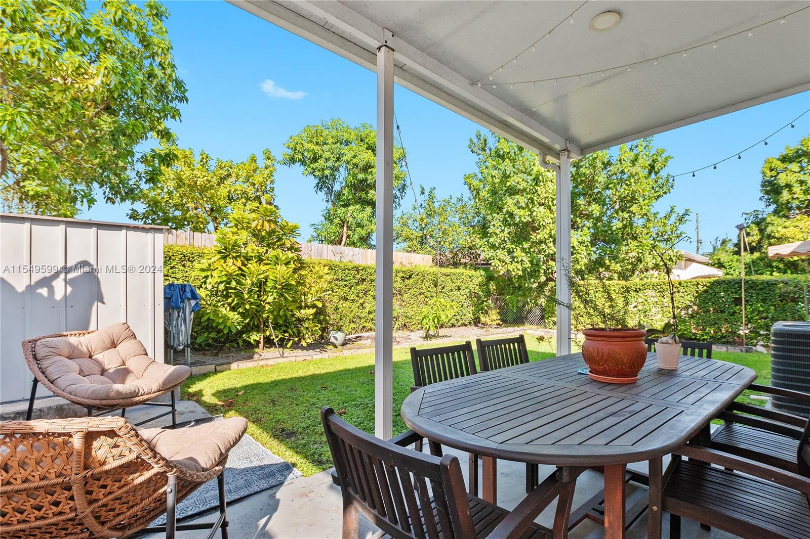 5819 Southwest 4th Street Miami, FL 33144 - Photo 24 of 27 a view of a patio with table and chairs potted plants and floor to ceiling window