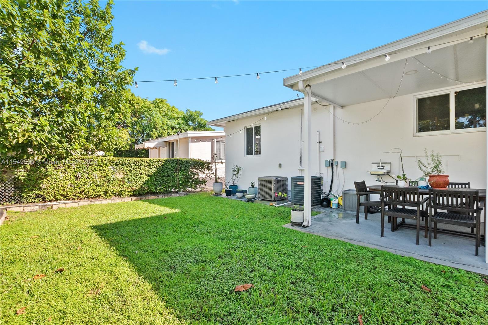 5819 Southwest 4th Street Miami, FL 33144 - Photo 25 of 27 a view of a patio with table and chairs potted plants and large tree