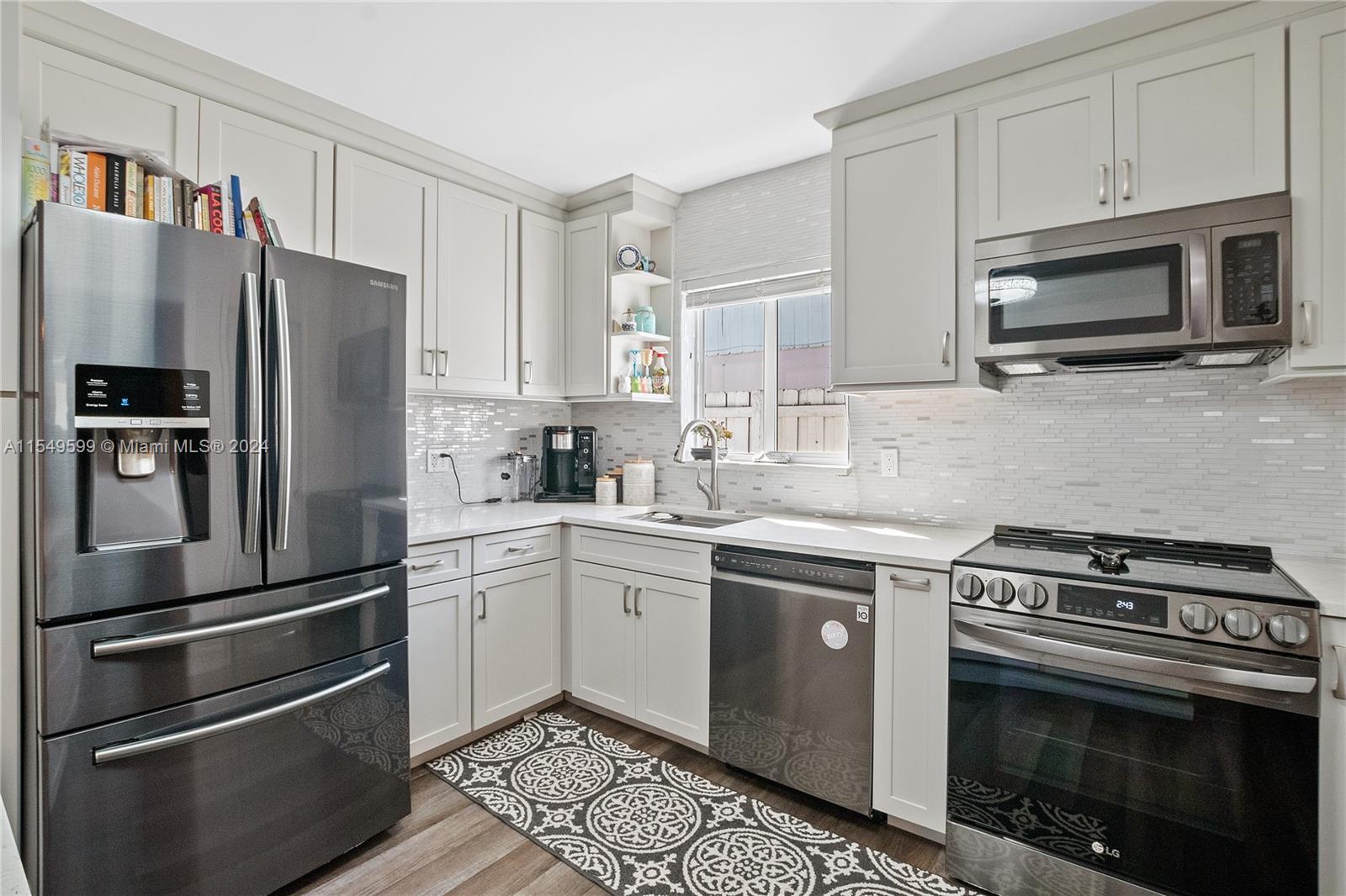 5819 Southwest 4th Street Miami, FL 33144 - Photo 7 of 27 a kitchen with stainless steel appliances and white cabinets