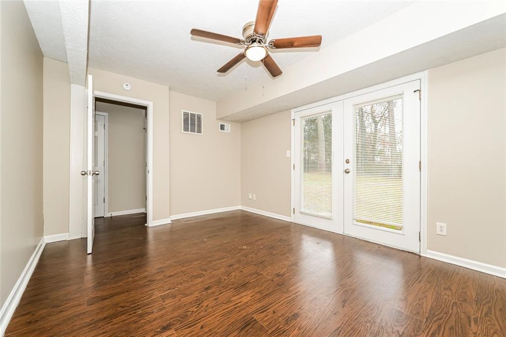107 Parkview Drive Stockbridge, GA 30281 - Photo 15 of 25 an empty room with wooden floor fan and windows
