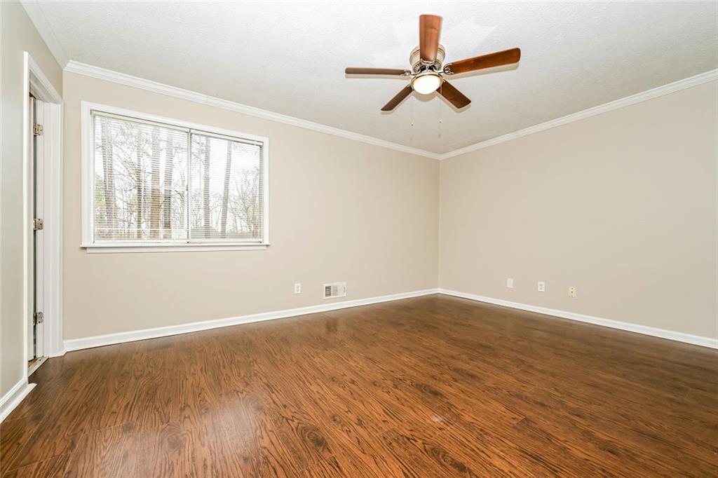 107 Parkview Drive Stockbridge, GA 30281 - Photo 19 of 25 an empty room with wooden floor fan and windows