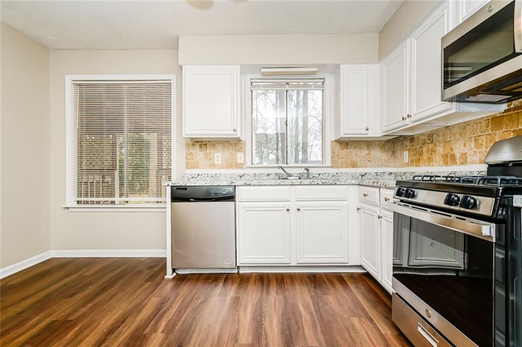 107 Parkview Drive Stockbridge, GA 30281 - Photo 20 of 25 a kitchen with a sink wooden floor and stainless steel appliances
