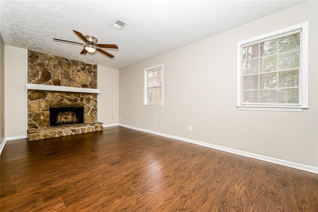 107 Parkview Drive Stockbridge, GA 30281 - Photo 23 of 25 an empty room with windows fireplace and wooden floor